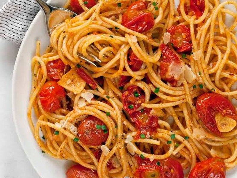 A bowl of pasta in a red cherry tomato sauce.