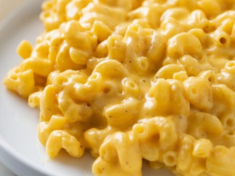 A bowl of creamy stovetop macaroni cheese, glossy with sauce.